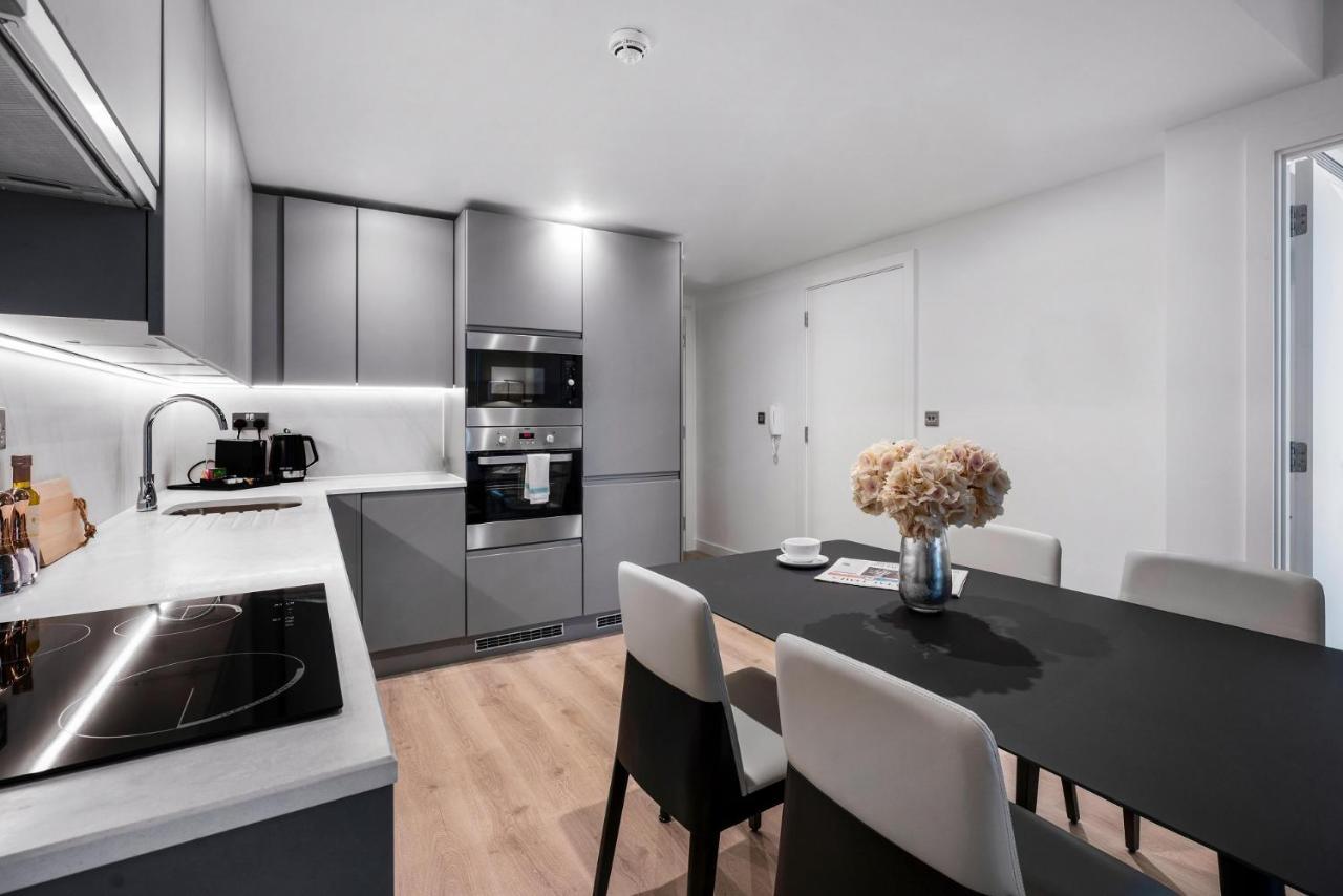Citysuites 2 Aparthotel Salford  Exterior foto The photo shows a modern kitchen and dining area. The kitchen features sleek gray cabinets, a countertop with an embedded cooktop, and built-in appliances, including an oven and microwave. There’s a small coffee maker on the counter. Adjacent to the 