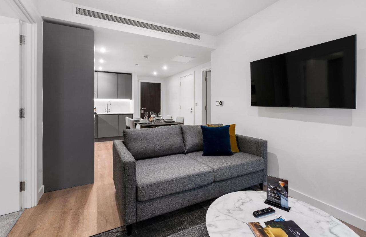 Citysuites 2 Aparthotel Salford  Exterior foto The photo shows a modern living space that includes a gray sofa with colorful cushions, a round marble coffee table, and a flat-screen TV mounted on the wall. In the background, there is a kitchen area featuring sleek cabinets. The flooring is light 