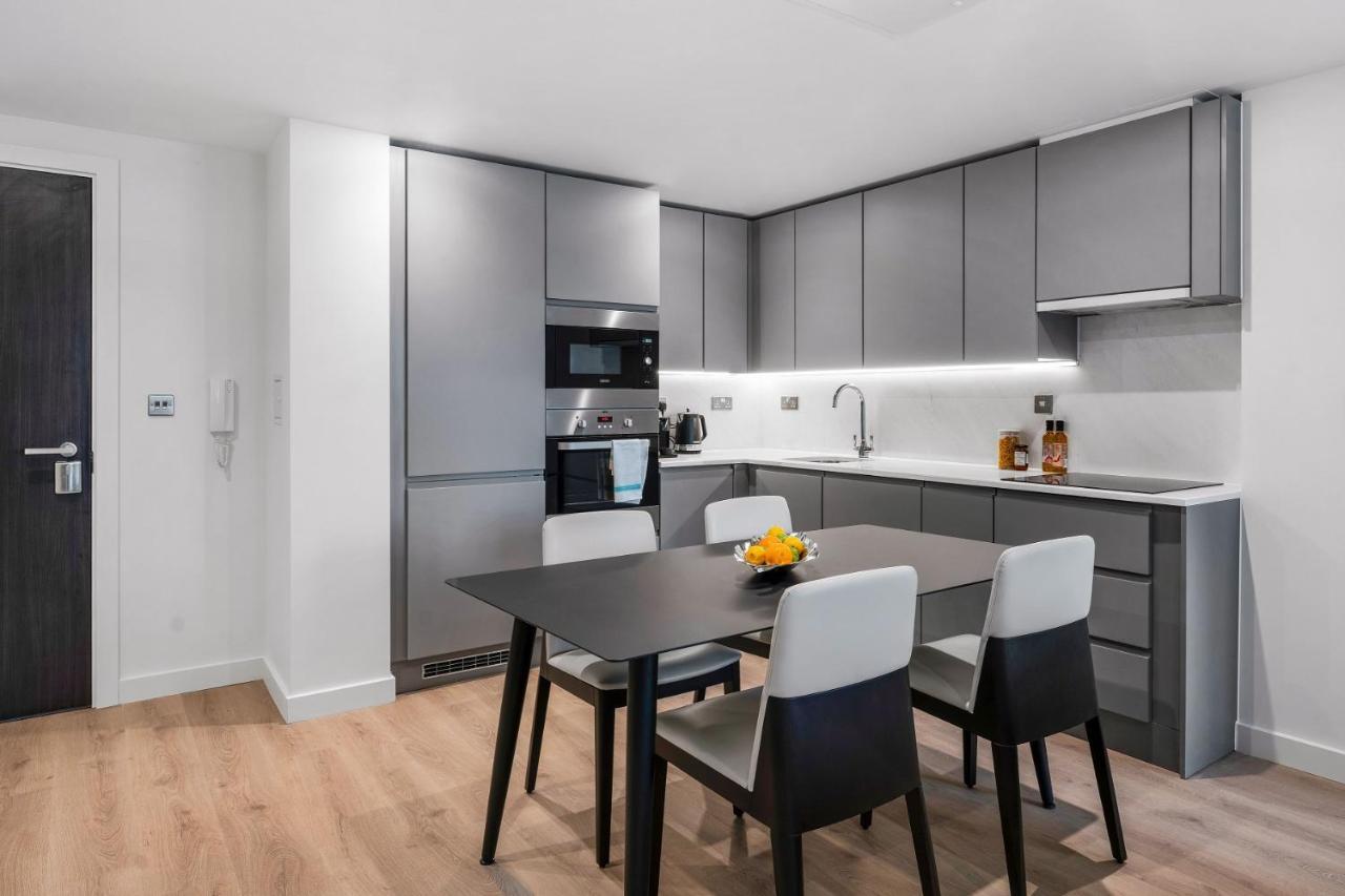 Citysuites 2 Aparthotel Salford  Exterior foto The photo shows a modern kitchen with a sleek and minimalist design. The cabinetry features a gray finish, and there are built-in appliances, including an oven and possibly a microwave. The countertop is light-colored, providing contrast to the darke